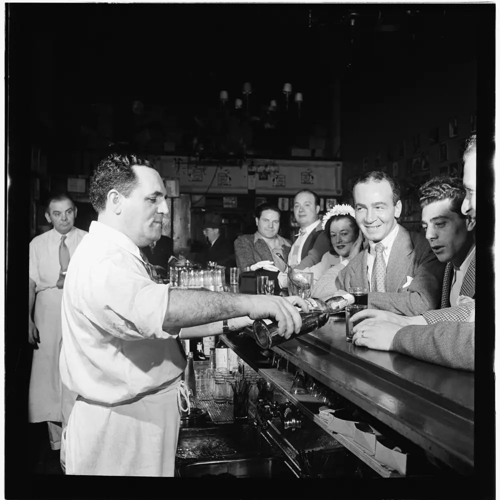 Barman schenkt in voor lachende gasten, Charlie's Tavern, New York, 1946